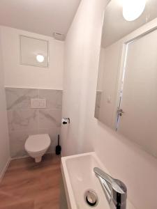 a white bathroom with a toilet and a sink at Grand duplex ensoleillé pour 7 Résidence Violaine in Le Monêtier-les-Bains +12 photos