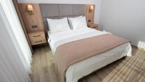 a bedroom with a large bed with white sheets and pillows at Altındere Vadi Hotel in Akyazı