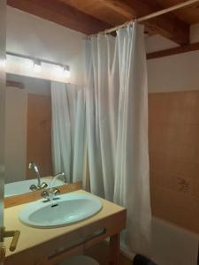 a bathroom with a sink and a white shower curtain at Cauterets in Cauterets