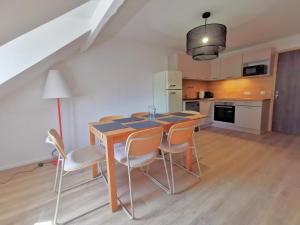 a kitchen with a table and chairs in a room at Grand duplex ensoleillé pour 7 Résidence Violaine in Le Monêtier-les-Bains