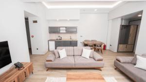 a living room with a couch and a kitchen at Altındere Vadi Hotel in Akyazı