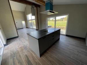a kitchen with a black island in the middle of a room at 1 New Dairy Barn in Sunderland Bridge +6 photos