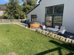 a backyard with a table and chairs and a grill at 1 New Dairy Barn in Sunderland Bridge