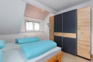 a bedroom with a bed with blue pillows at Ferienwohnung Weinbergblick in Auggen