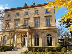 un gran edificio de piedra con árboles delante de él en Home Parc by So Homy - 3 Bed Room, 6 People, en Saint-Ouen
