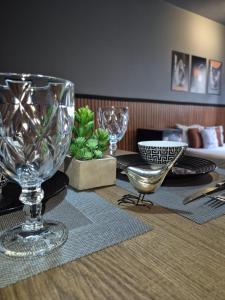 a table with plates and wine glasses on top of it at Studio quartzo cinza - centro in Campos dos Goytacazes