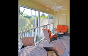 un balcone con sedie e un divano e un ventilatore a soffitto di Holiday House 3 a Point O'Rocks Altre 23 foto