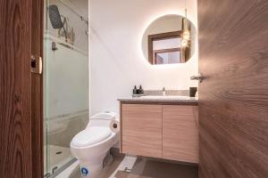 a bathroom with a toilet and a sink and a mirror at Nogal Getaway! in Hacienda Sigsipamba +30 photos