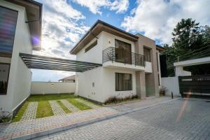 a white house with a courtyard in front of it at Nogal Getaway! in Hacienda Sigsipamba