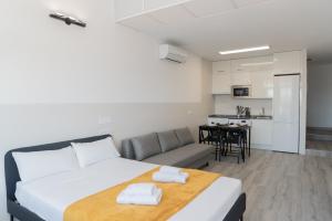 a bedroom with a bed and a couch and a kitchen at Oriel family loft in Coslada