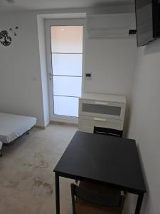 Robion en LuberonにあるCanto Cigalo Rdc 1のデスク、テーブル、ベッドが備わる客室です。