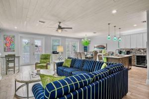 a living room with blue couches and a kitchen at Salty Margarita in Anna Maria Island