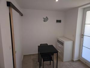 a dining room with a black table and a cabinet at Canto Cigalo Rdc 2 in Robion en Luberon