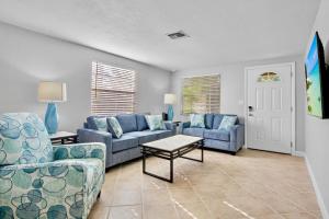 a living room with two blue couches and a table at Gulf Haven East in Anna Maria Island