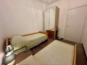 a small bedroom with two beds and a mirror at Casa Susanna Loano in Loano