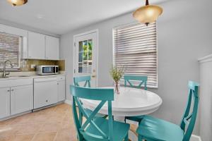 a kitchen with a white table and blue chairs at Gulf Haven East in Anna Maria Island +26 photos