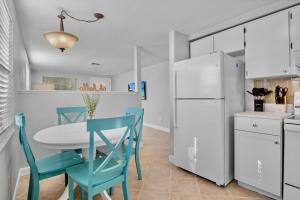 a kitchen with a table and chairs and a white refrigerator at Gulf Haven East in Anna Maria Island