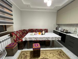 a kitchen with a table and a couch in it at Abylay Guesthouse in Jangy-Talap