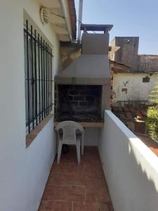 a balcony with a fireplace and a chair on it at CERCA DEL MAR - Costa Azul in Costa Azul