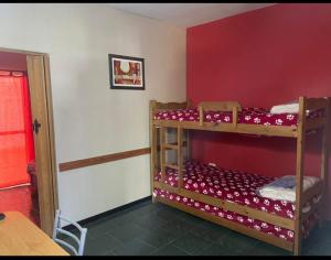 two bunk beds in a room with a red wall at CERCA DEL MAR - Costa Azul in Costa Azul