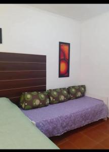 a bedroom with a bed with a headboard and a purple couch at CERCA DEL MAR - Costa Azul in Costa Azul