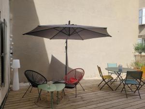 a patio with a table and chairs and an umbrella at Le Baron terrasse et parking cœur de Castres in Castres