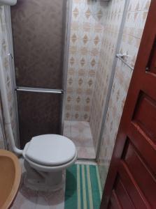 a small bathroom with a toilet and a shower at Casa para COP 30 dois quartos in Ananindeua