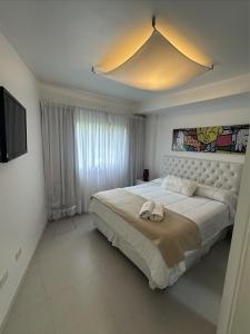 a bedroom with a large bed and a television at Arenas Calidas Carilo in Carilo
