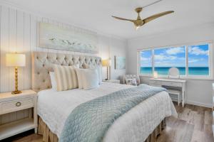 een slaapkamer met een bed en een raam met uitzicht op de oceaan bij Shimmering Shores in Anna Maria Island