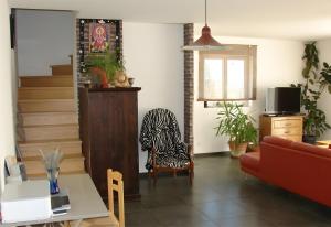 una sala de estar con un sofá y una silla en Villa Les Escouls, en Ribes