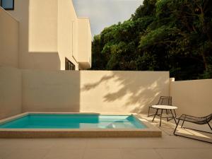 a swimming pool with a table and a chair next to a building at URUUMI Onna Pool Villa ｳﾙｳﾐ ｵﾝﾅ ﾌﾟｰﾙ ｳﾞｨﾗ -公式- in Onna