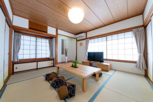 a living room with a table and a tv at Haleluana SHIBAMATA in Tokyo