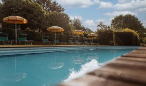 a swimming pool with chairs and umbrellas at Bio Agriturismo I Lapi in Catabbio +28 photos