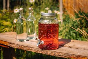 a jar of jam sitting on a wooden table with two bottles at Landhoeve in Zwarteweg