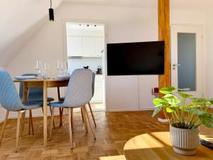 Un comedor con mesa y sillas y un televisor. en Turmblick - Parkplatz - A7 Nähe - Bahnhof Nähe - mit WM, en Illertissen