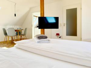 Una cama blanca con un televisor de pantalla plana encima. en Turmblick - Parkplatz - A7 Nähe - Bahnhof Nähe - mit WM, en Illertissen