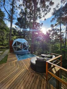 a deck with a fire pit and a grill on it at Domo Real in Nova Friburgo