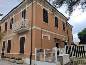 un edificio naranja con una valla blanca delante de él en Casa al mare di Nonno Robi, en Fano