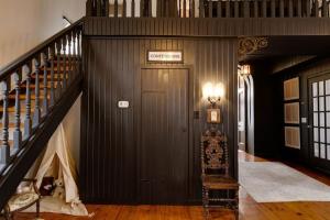 a hallway with a staircase and a door in a house at The Prince Edward County Church, A Unique Escape in Belleville