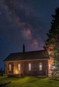 an old house at night with a starry sky at The Prince Edward County Church, A Unique Escape in Belleville