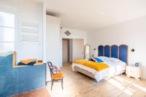 a bedroom with a large bed and a chair at Gite Du Val D'egray in Champdeniers-Saint-Denis