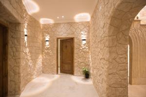 a hallway with stone walls and a wooden door at Secrets Of The Pyramids Hotel in Cairo +88 photos