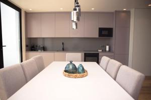 a kitchen with a white table with chairs at Casa Dona Isabel - ocean suites in Lagoa