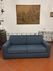 a blue couch in a room with a painting on the wall at Casa di Anchiano in Borgo a Mozzano