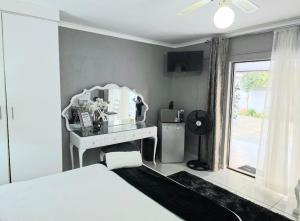 a bedroom with a bed and a desk with a microwave at Zhantique Guest House 1- Unit 1 in Boksburg