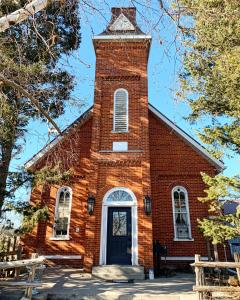 a red brick church with a clock tower at The Prince Edward County Church, A Unique Escape in Belleville