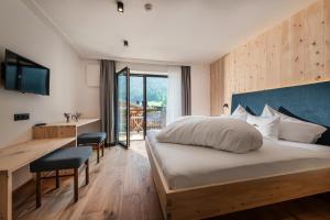 セストにあるChalet Rudlaのベッドと机とテレビがあるホテルの部屋
