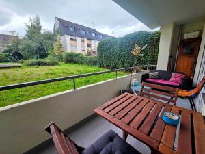 a balcony with a wooden table and chairs and a window at Design-Wohnung im Zentrum mit Balkon und Parkplatz in Offenbach