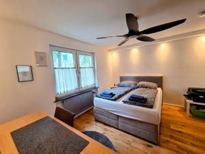 a bedroom with a bed and a ceiling fan at Design-Wohnung im Zentrum mit Balkon und Parkplatz in Offenbach +26 photos