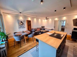 a kitchen and living room with a table and a couch at Design-Wohnung im Zentrum mit Balkon und Parkplatz in Offenbach